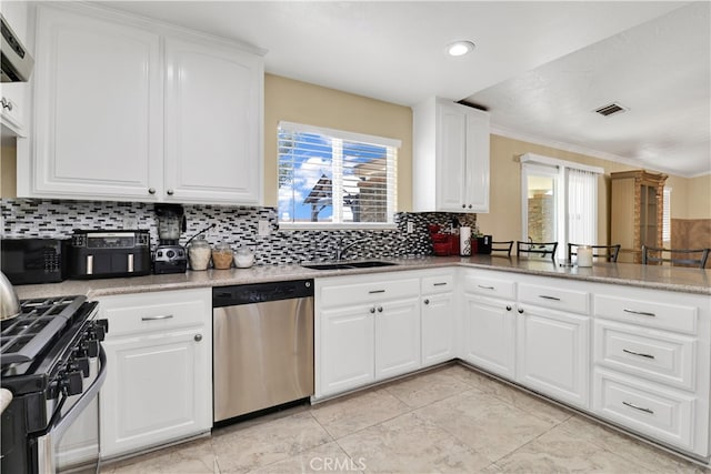 kitchen with stainless steel appliances, backsplash, ornamental molding, sink, and white cabinetry