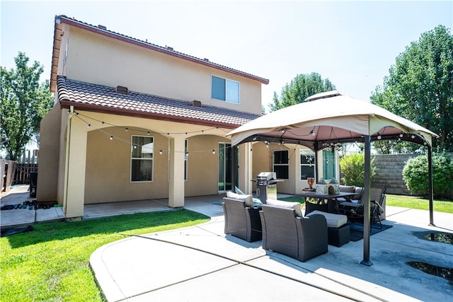 rear view of property featuring a gazebo and a patio