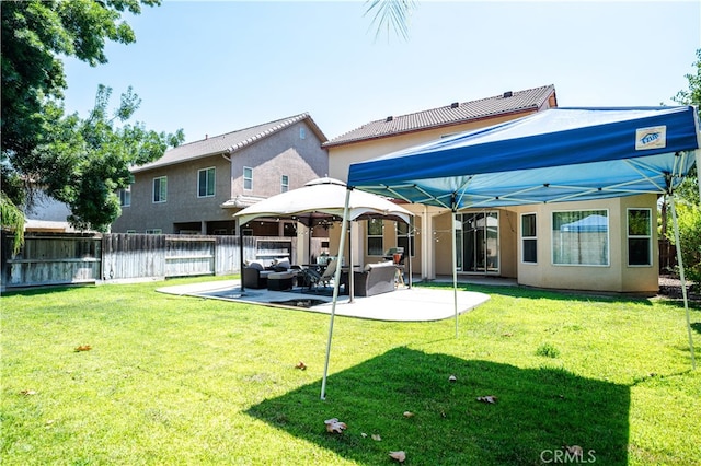 back of property with a lawn, outdoor lounge area, and a patio area