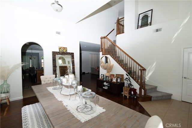 dining area with a towering ceiling and dark hardwood / wood-style floors