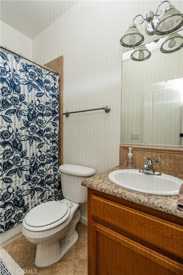 bathroom with tile patterned flooring, vanity, and toilet