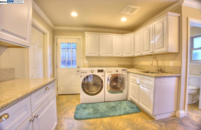 laundry area with washer and dryer, cabinets, ornamental molding, and sink