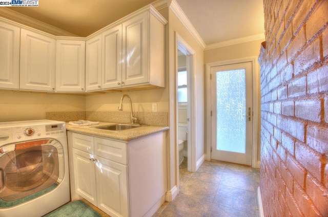 laundry room featuring cabinets, sink, light tile patterned floors, ornamental molding, and washer / clothes dryer