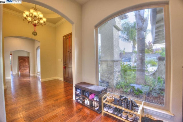 interior space with crown molding, hardwood / wood-style floors, and a notable chandelier