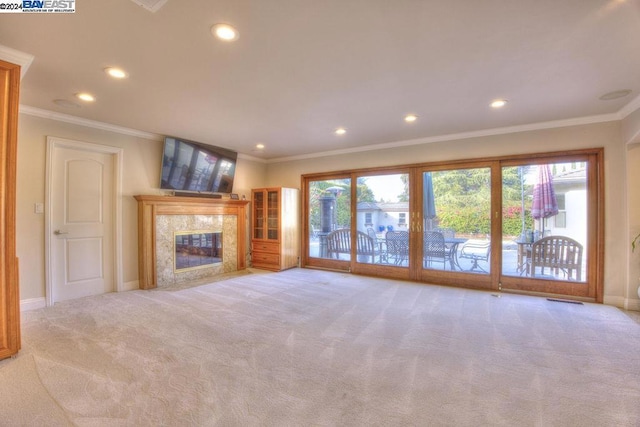 unfurnished living room with light carpet, a fireplace, and ornamental molding