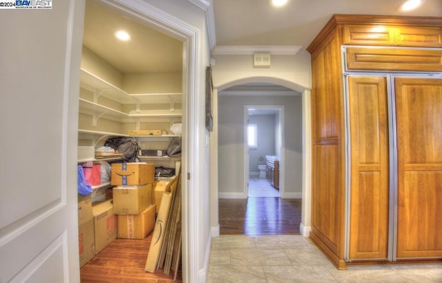 corridor featuring crown molding and light hardwood / wood-style flooring