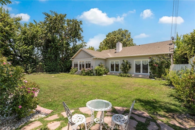 back of house with a lawn and french doors