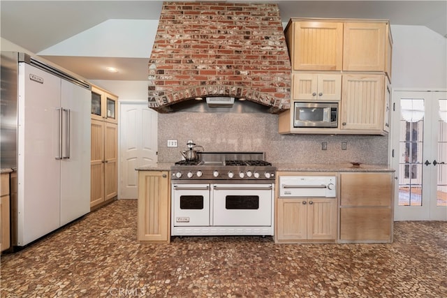 kitchen with premium appliances, light brown cabinets, stone countertops, and tasteful backsplash