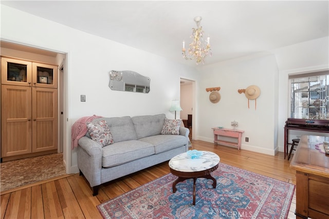 living room with light hardwood / wood-style floors and an inviting chandelier