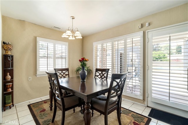 tiled dining area featuring a wealth of natural light and an inviting chandelier