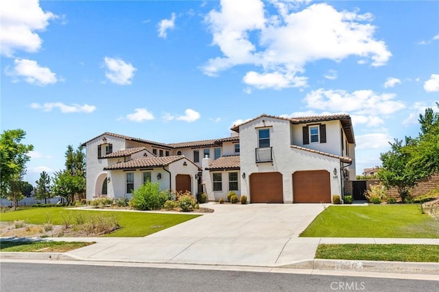 mediterranean / spanish-style home featuring a tile roof, concrete driveway, stucco siding, a front lawn, and a garage