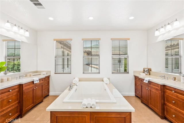 bathroom featuring tile patterned floors, vanity, and a bathing tub