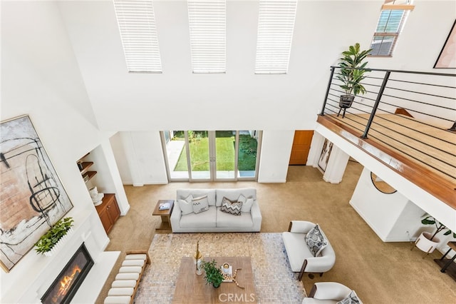 carpeted living room featuring a towering ceiling