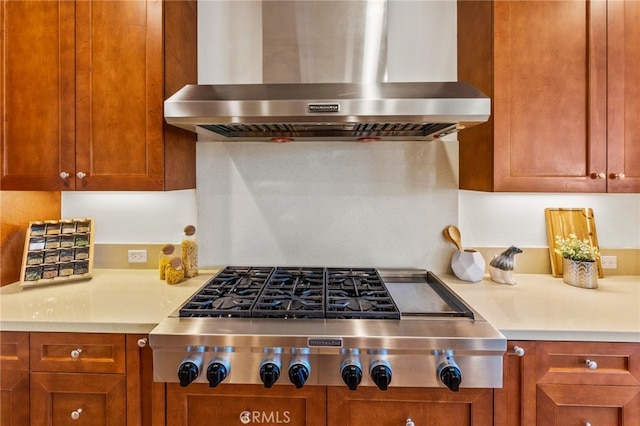 kitchen with stainless steel gas stovetop and wall chimney range hood