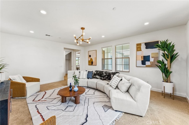 carpeted living room with an inviting chandelier