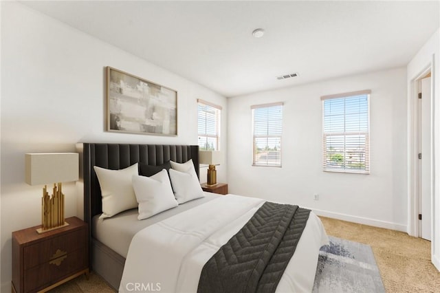 bedroom featuring baseboards, visible vents, multiple windows, and carpet
