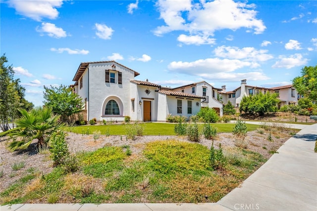 mediterranean / spanish-style home featuring a front lawn