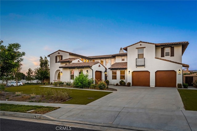 mediterranean / spanish-style house featuring a yard and a garage