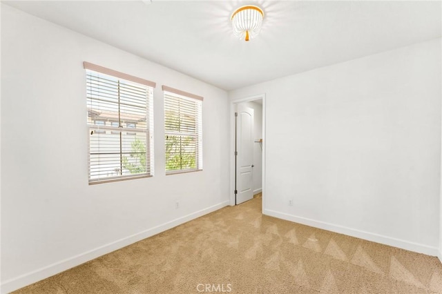 empty room with light carpet and baseboards