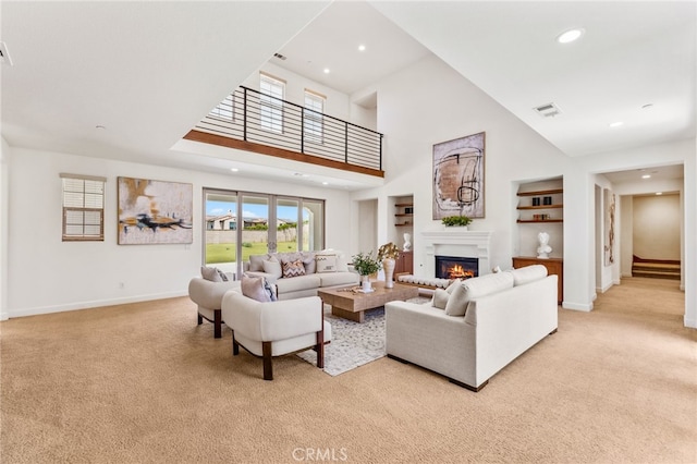 carpeted living room featuring built in shelves and a towering ceiling