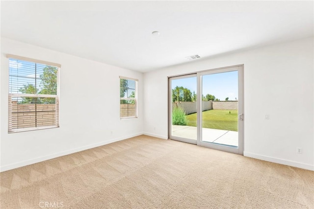 unfurnished room with carpet floors, baseboards, and visible vents