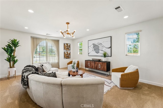 carpeted living room with an inviting chandelier