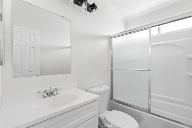 full bathroom featuring ornamental molding, vanity, toilet, and bath / shower combo with glass door