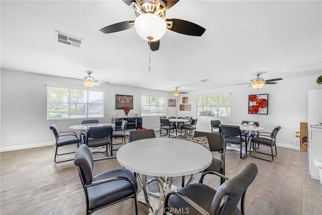 dining area with wood finished floors, visible vents, and baseboards