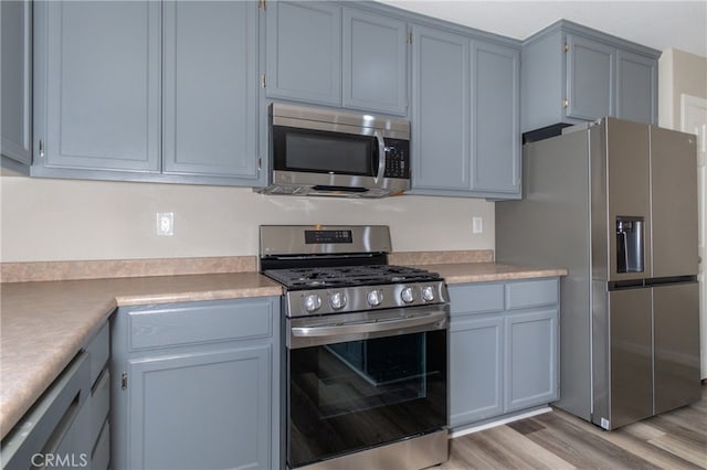 kitchen with stainless steel appliances and light hardwood / wood-style floors