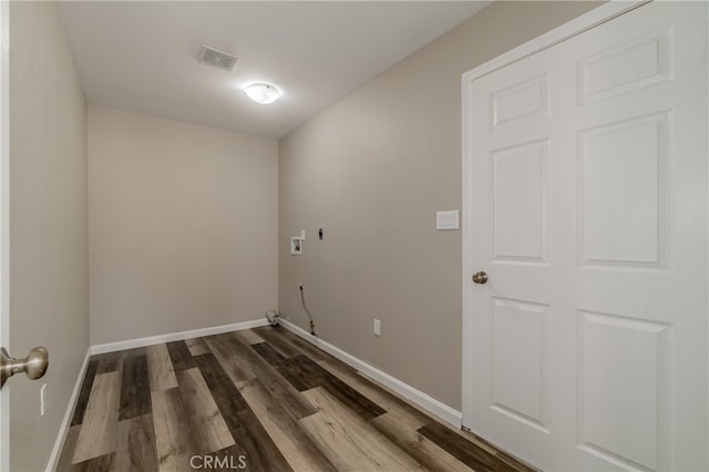 clothes washing area with hardwood / wood-style floors and washer hookup