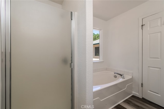 bathroom featuring independent shower and bath and hardwood / wood-style floors