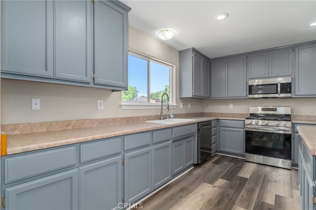 kitchen featuring appliances with stainless steel finishes, sink, and dark hardwood / wood-style flooring