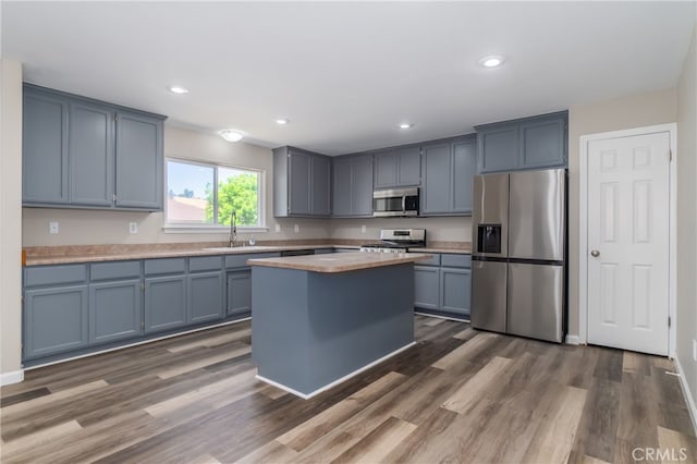 kitchen with a center island, sink, dark wood-type flooring, and stainless steel appliances