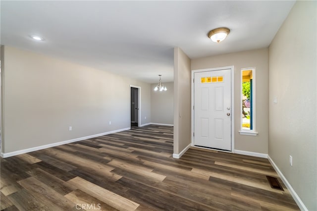 entrance foyer with an inviting chandelier and dark hardwood / wood-style floors