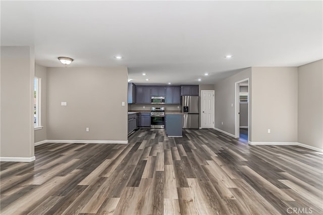 kitchen with appliances with stainless steel finishes and dark hardwood / wood-style floors