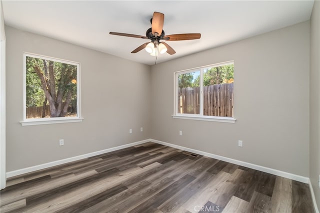 empty room with ceiling fan and dark hardwood / wood-style floors