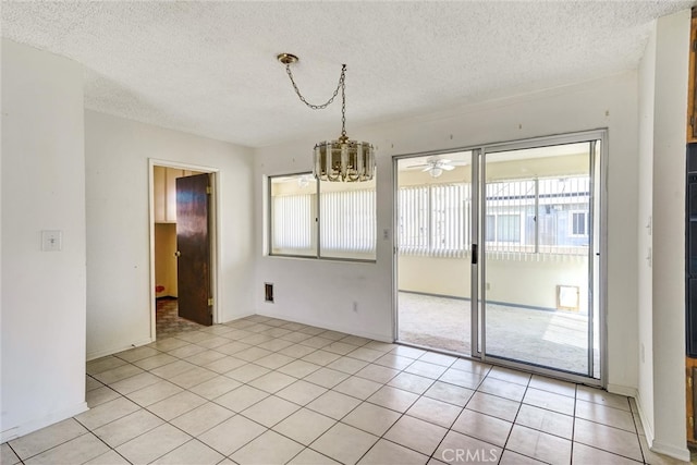 spare room with ceiling fan with notable chandelier, a textured ceiling, and light tile patterned floors