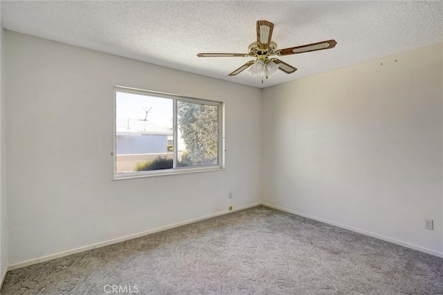 carpeted spare room featuring ceiling fan and a textured ceiling