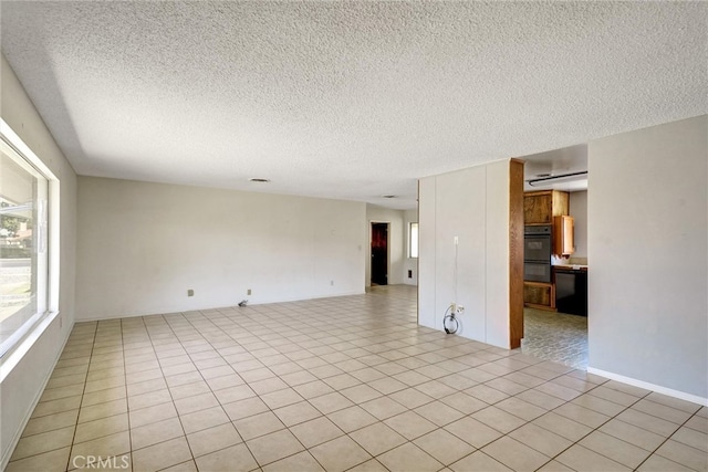 spare room featuring a textured ceiling and light tile patterned floors