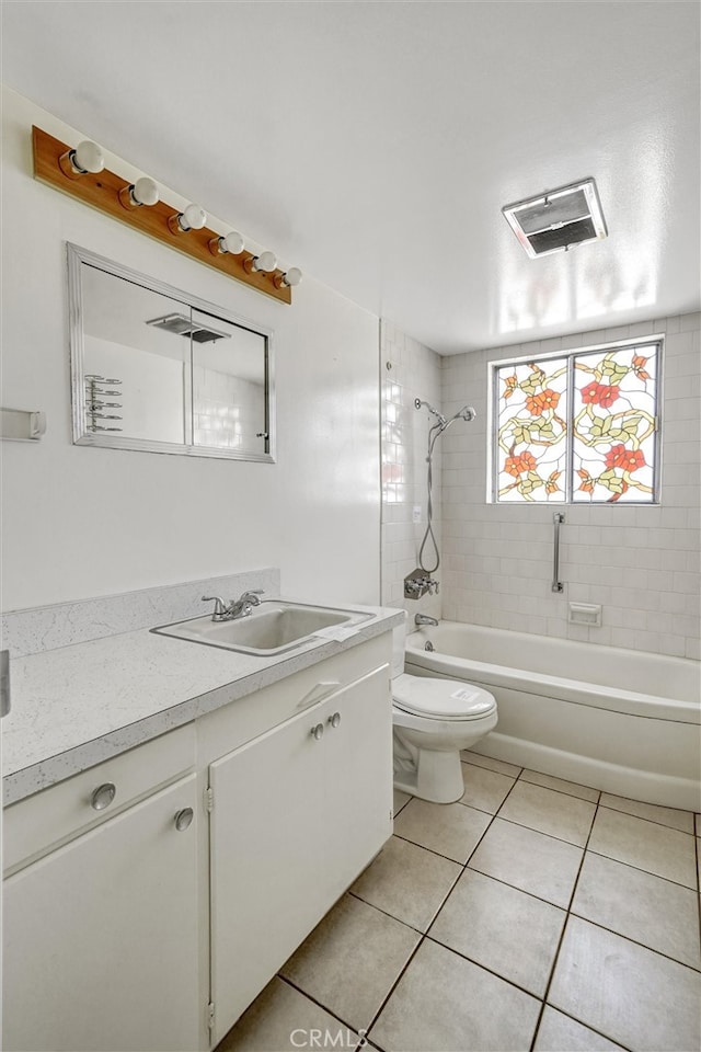 full bathroom featuring tiled shower / bath, vanity, toilet, and tile patterned floors