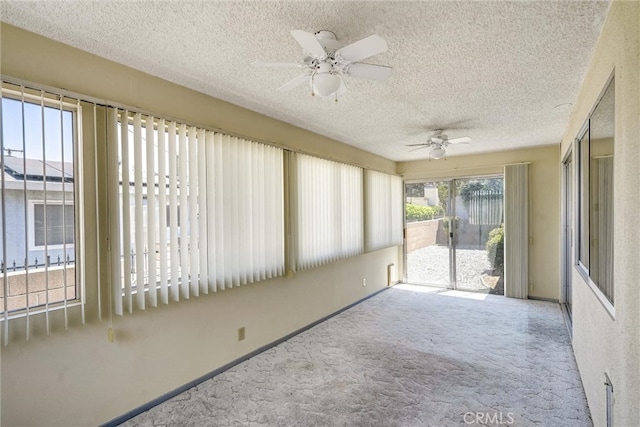 unfurnished sunroom with ceiling fan