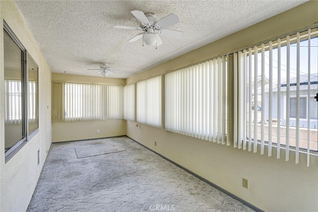 unfurnished sunroom with ceiling fan