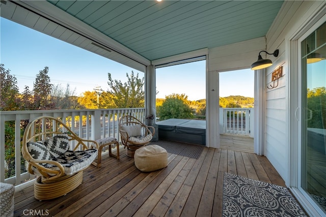 wooden deck with a covered hot tub