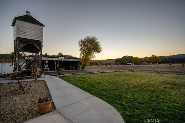 yard at dusk featuring a patio