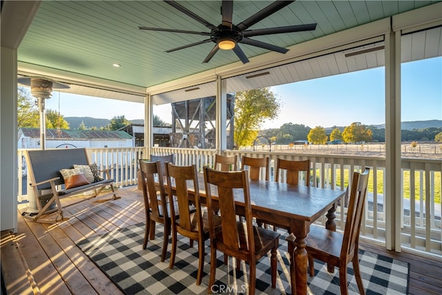 sunroom with ceiling fan, wooden ceiling, and a mountain view