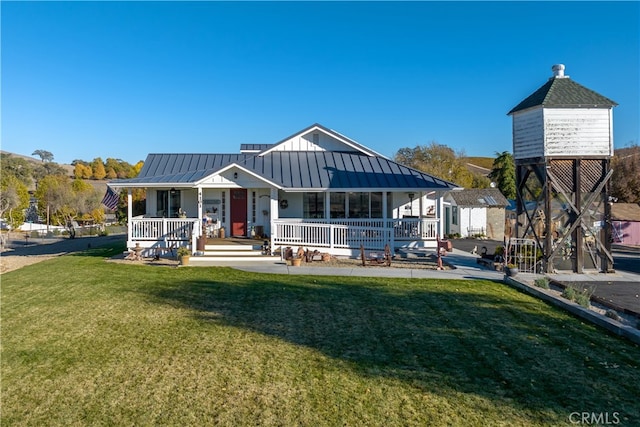 rear view of house featuring a yard, a storage unit, and a porch