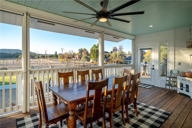 sunroom with a mountain view and ceiling fan