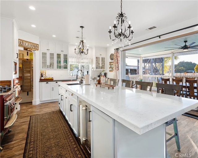 kitchen with a spacious island, sink, white cabinets, and tasteful backsplash