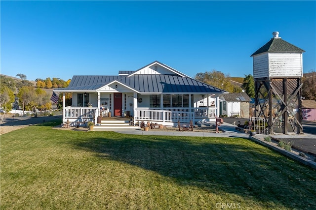 back of property with a yard, a porch, and a shed