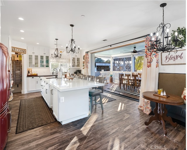 kitchen with a center island with sink, sink, white cabinetry, and dark hardwood / wood-style flooring